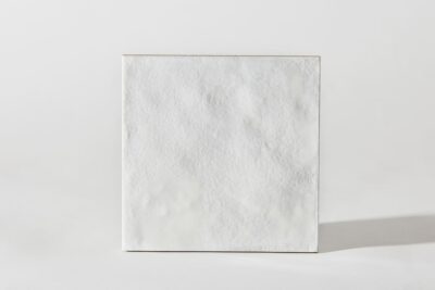 Kwadratowa płytka ceramiczna, kolor biały, widok powierzchni.