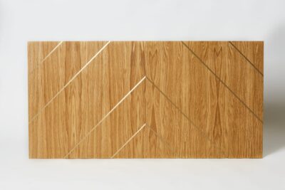 Dwa panele drewniane z listwami mosiężnymi, tworzące wzór.
