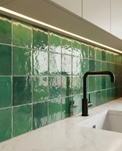 Zielone płytki pomiędzy szafkami w kuchni Harmony Riad Green 10x10cm. Kafelki kwadratowe, retro, błyszczace.