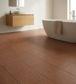 Wnętrze nowoczesnej, minimalistycznej łazienki, podłoga z płytkami Marca Corona Terrasale COTTO 20x20 K243, wiszącą drewnianą szafką z umywalką nablatową i białą wolnostojącą wanną.