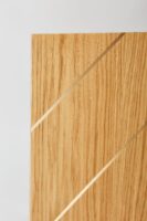 Widok panelu drewnianego z bliska. Błyszczące dwie listwy mosiężne. Panele drewniane na ścianę do salonu.