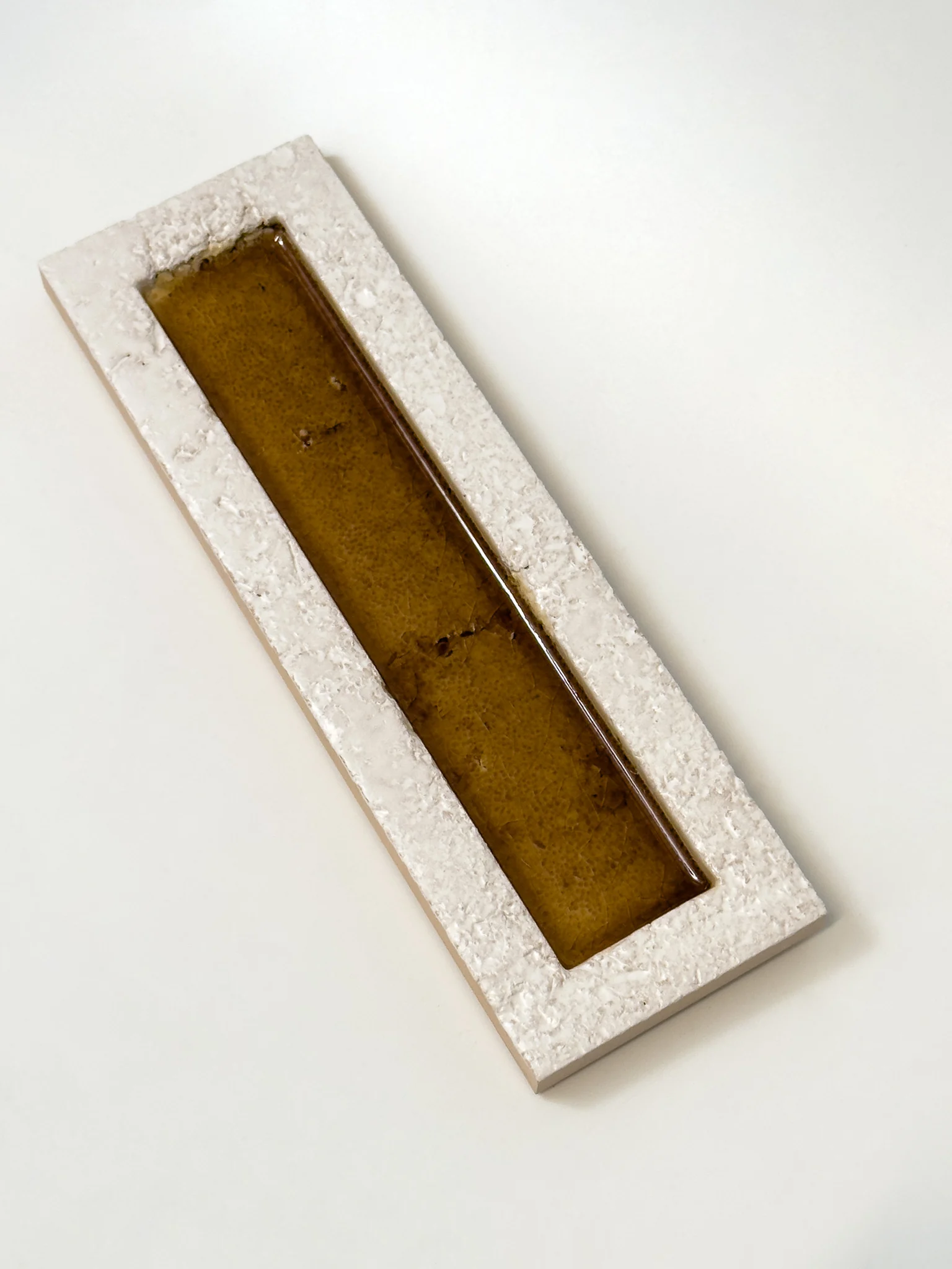 Płytka 3d dekoracyjna cegiełka brązowa Natucer SUNRISE-W BROWN 8x27. Płytka ceramiczna z brązowym, błyszczącym paskiem i matową, białą ramką.