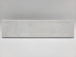 Cegiełka biała płytka - Peronda Harmony Bari White 6×24,6 cm. Kafelka z błyszczącą, lekko wklęsłą powierzchnią na ścianę z ciemnymi przetarciami.