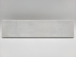 Cegiełka biała płytka - Peronda Harmony Bari White 6×24,6 cm. Kafelka z błyszczącą, lekko wklęsłą powierzchnią na ścianę z ciemnymi przetarciami.
