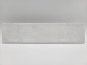 Cegiełka biała płytka - Peronda Harmony Bari White 6×24,6 cm. Kafelka z błyszczącą, lekko wklęsłą powierzchnią na ścianę z ciemnymi przetarciami.