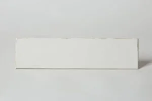 Glazura cegiełka biała - Mykonos Mallorca Yebala White 7,5x30cm. Płytka ceramiczna w małym rozmiarze z błyszczącą powierzchnią z drobnymi, rdzawymi kropeczkami.
