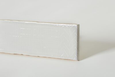 Płytka cegiełka biała połysk z abstrakcyjnym wzorem na powierzchni, Peronda Harmony Pasadena White 7.5x30cm. Wzór na płytce występuje w 8 wersjach, na zdjęciu jeden wariant.