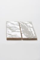 Dwie białe płytki ścienne, cegiełki z błyszczącą, nieregularną powierzchnią - Harmony RIAD WHITE 6.5x20cm. Płytki idealne do łazienki na ścianę lub jako fartuch kuchenny.