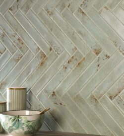 Płytki cegiełki, zielone z efektem rdzy na ścianie - Natucer Cool Emerald 5x30cm. Kafelki ułożone w jodełkę.