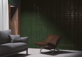 Salon z zielonymi płytkami na ścianie, Peronda Harmony Poitiers Green 7,5 x 30cm. Pomieszczenie z szarą sofą i brązowym fotelem | cerammind.com - zielone płytki.