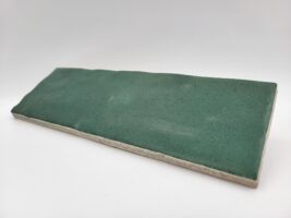 Zielona płytka cegiełka, Harmony Sahn green 6,5x20cm. Matowe kafelki do kuchni z powierzchnią, na której widoczne są ślady rąk rzemieślnika.