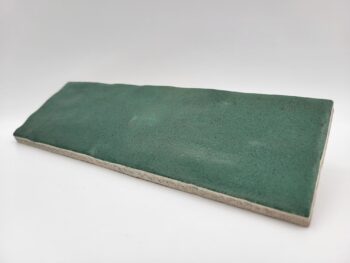 Zielona płytka cegiełka, Harmony Sahn green 6,5x20cm. Matowe kafelki do kuchni z powierzchnią, na której widoczne są ślady rąk rzemieślnika.