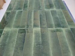 Zielone płytki łazienkowe - Marazzi Crogiolo Lume MA9M. Widok na różne warianty błyszczących płytek z kolekcji Lume Forest. Ściana w łazience z tymi kafelkami, nie będzie jednolita, na zdjęciu widoczne różnice wzoru i koloru.