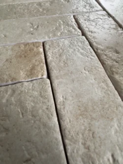 Beżowe płytki ceramiczne o strukturze kamienia, układane w jodełkę, kolekcja ABBEY Limenstone 5x25cm