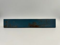 Niebieskie kafelki metalizowane - Natucer Cool Navy 5x30cm. Płytki cegiełki z satynowa powierzchnią z widocznymi śladami rdzy, przeznaczone na ścianę.