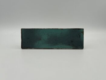 Niebieskie kafle łazienkowe - Estudio Amazonia Sapphire 6,5x20 cm. Cegiełki ceramiczne ścienne w połysku, z rdzawymi przebarwieniami.