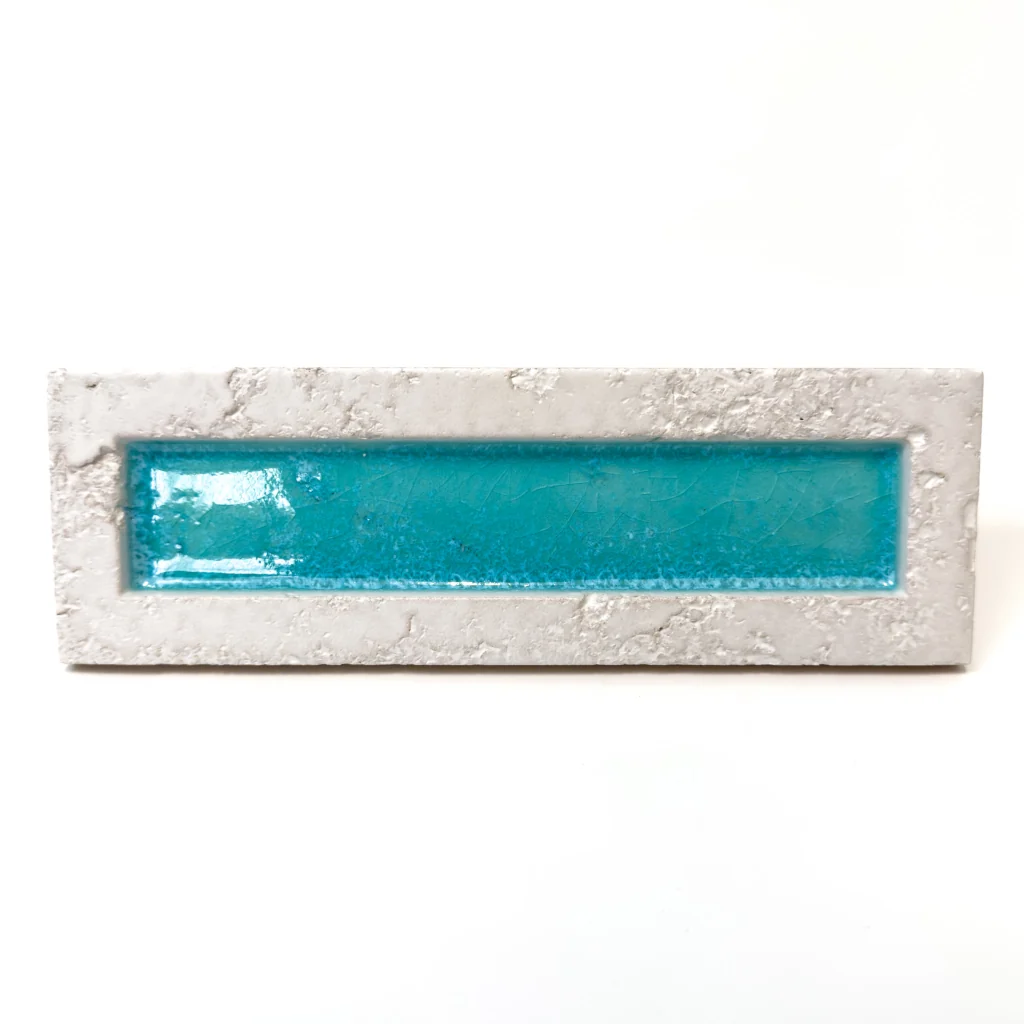 Płytka 3d cegiełka turkusowa Natucer Sunrise-W Blu 8x27. Płytka ma turkusowy (morski) kolor w części błyszczącej oraz białą (lekko rustykalną) ramkę.