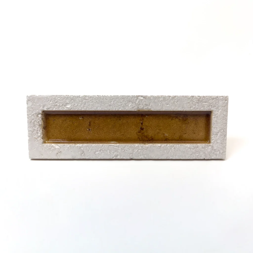 Płytka 3d dekor cegiełka brązowa - Natucer SUNRISE-W BROWN 8x27 cm. Płytka ma wąski pasek w kolorze bursztynowo-brązowym / miodowym, i białą chropowatą, lekko fakturowaną ramkę.