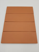 Harmony Glint Clay Matt 5x15 - brązowe, małe płytki w kolorze cegły z matową, lekko nierówną powierzchnią.