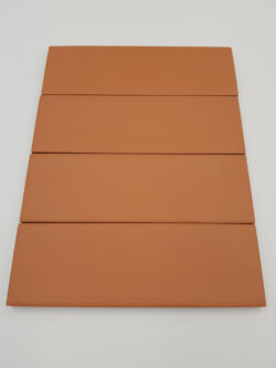 Harmony Glint Clay Matt 5x15 - brązowe, małe płytki w kolorze cegły z matową, lekko nierówną powierzchnią.