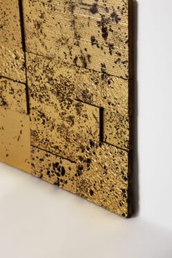 Dekory na ścianę - złote, 3D z efektem kamienia i wżerami na powierzchni płytki.