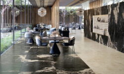 Restauracja z włoskimi płytkami na podłodze, imitującymi marmur w kolorze beżowym i czarnym.