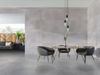 Płytki imitujące beton do salonu 120x60 - Absolut Cozumel. Szare płytki ceramiczne na podłodze i ścianie w salonie., Szare fotele, drewniany blat stołu.