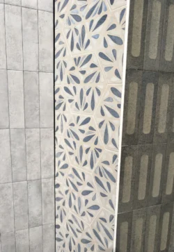 Płytki heksagon na ścianie Marca Corona Terracreta DIPINTO MARNA 25x21,6cm. Kafle szare z dekoracyjnym biało-niebieskim wzorem.