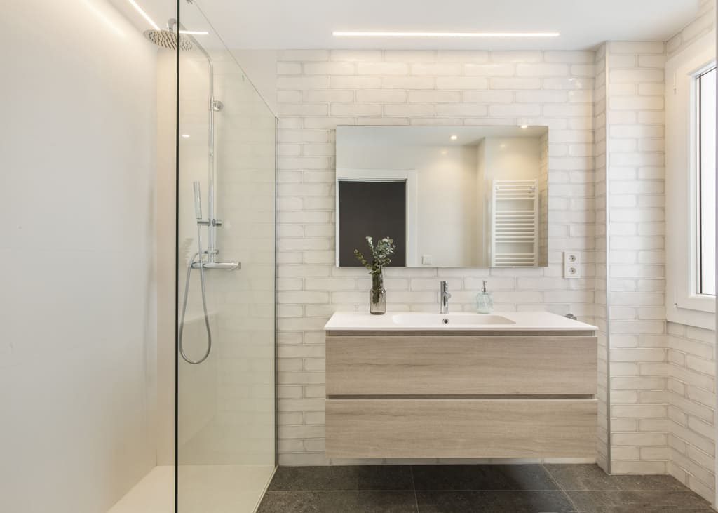 Biała łazienka z płytkami cegiełkami na ścianie, Peronda Harmony Highland White 7,5x30cm. Łazienka z prysznicem, lustrem i umywalką.