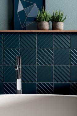 Kafelki 3d do łazienki - MARCA CORONA 4D diagonal deep blue 20x20cm. Ściana nad wanną z ciemnoniebieskimi płytkami 3d w kwadratowym formacie.
