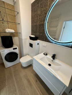 Kafelki retro do łazienki - Peronda FS Saja 33x33 cm. Łazienka z hiszpańskimi kafelkami retro 3D, Biała umywalka, pralka, sedes i drewnopodobna podłoga.