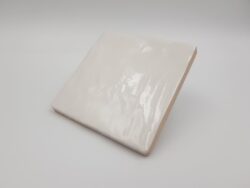 Kwadratowe płytki na ścianę - Harmony Riad white 10x10. Białe kafelki z lekko nierówna, błyszczącą powierzchnią, wzorowaną na ręcznie wyrabianej glinie.