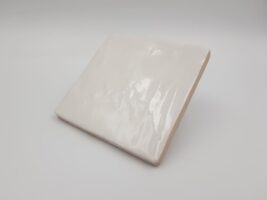 Kwadratowe płytki na ścianę - Harmony Riad white 10x10. Białe kafelki z lekko nierówna, błyszczącą powierzchnią, wzorowaną na ręcznie wyrabianej glinie.