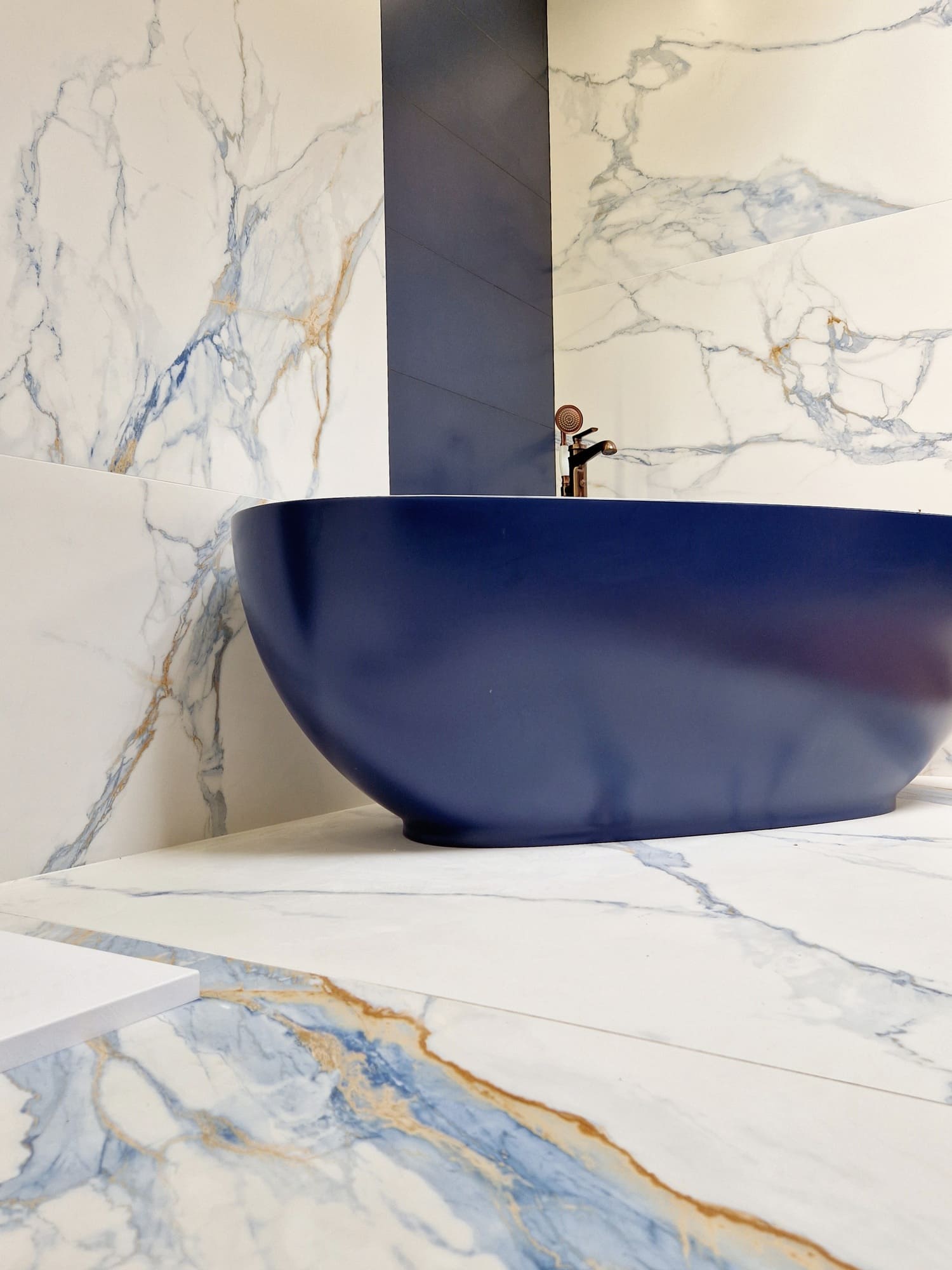 Łazienka biało niebieska inspiracje - Peronda Museum PRALINE BLUE SP 100x100 R. Płytki marmurowe z niebieską żyłką na podłodze i ścianie w łazience.