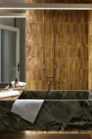 Beżowe płytki w łazience na ścianie - MARAZZI Lume Beige Lx 6x24cm. Włoska glazura na podłogę lub ścianę. Na zdjęciu zielona - marmurowa wanna.