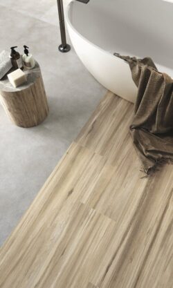 Płytki łazienkowe imitacja betonu - APE Work b cenere. Płytki na podłodze w łazience, imitujące beton w kolorze szarym.