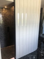 Łazienka z błyszczącymi płytkami ozdobnymi na ścianie, Peronda Harmony BOW WHITE 15x45cm. Hiszpańskie płytki łazienkowe, dekoracyjne z powierzchnią błyszczącą i wygiętym kształtem dachówki w kolorze białym.