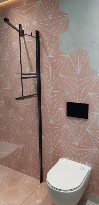 Różowy prysznic heksagon z płytkami APE Klen na podłodze i ścianie. Pomieszczenie z ubikacją i prysznicem.