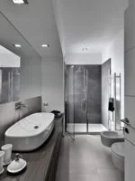 Szara łazienka z płytkami imitującymi kamień - SINTESI Ecoproject silver - podłoga, SINTESI Ecoproject smoke - ściana, prysznic.