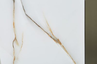 Kafelki marmurowe białe - Absolut Keramika Islandia. Hiszpańskie płytki imitujące biały marmur z szarym i złotym żyłkowaniem. Płytki łazienkowe lappato na podłogę i ścianę.