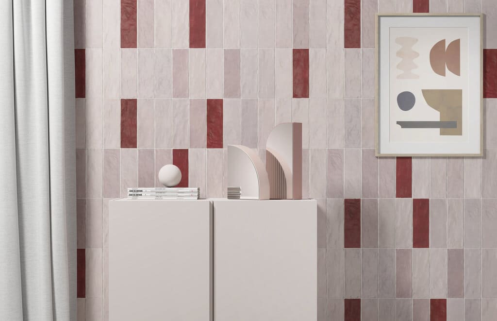 Płytki Harmony Sahn Pink 6,5x20 ułożone pionowo z akcentami Sahn Red, za białą komodą z grafiką na ścianie