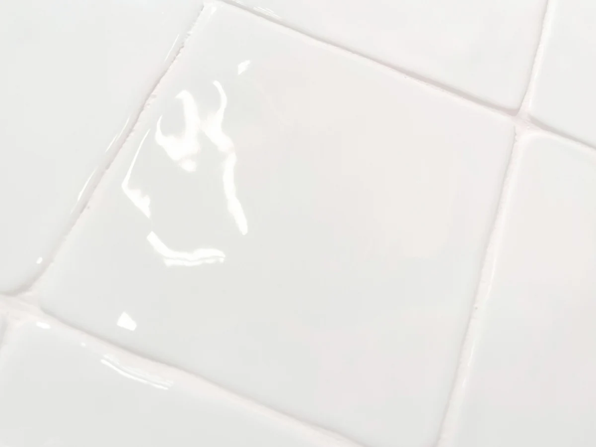 Białe płytki kwadratowe, rustykalne, błyszczące, nieregularne krawędzie - Harmony HANA WHITE 12x12. Zbliżenie na powierzchnię.